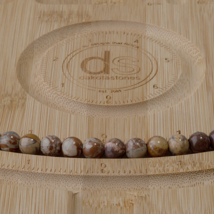 This is a Dakota Stones 8mm Birds Eye Rhyolite Large Hole Gemstone strand with round beads in 8 inch strand.