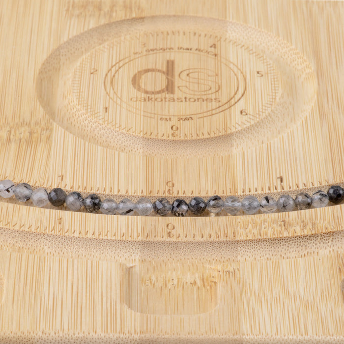 This is a Dakota Stones 4mm Black Rutilated Quartz Micofaceted Gemstone strand with round beads in 15-16 inch strand.