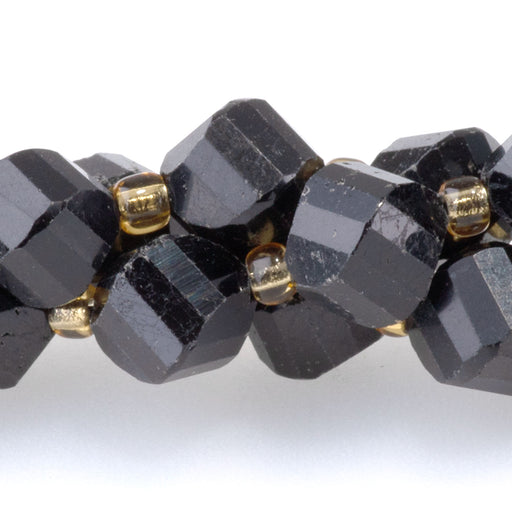 This is a Dakota Stones 7x8mm Black Tourmaline Swirl Gemstone strand with faceted oval beads in 15-16 inch strand.