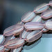 This is a Dakota Stones 13x22-30mm Pink Chalcedony Gemstone strand with oval beads in 15-16 inch strand.