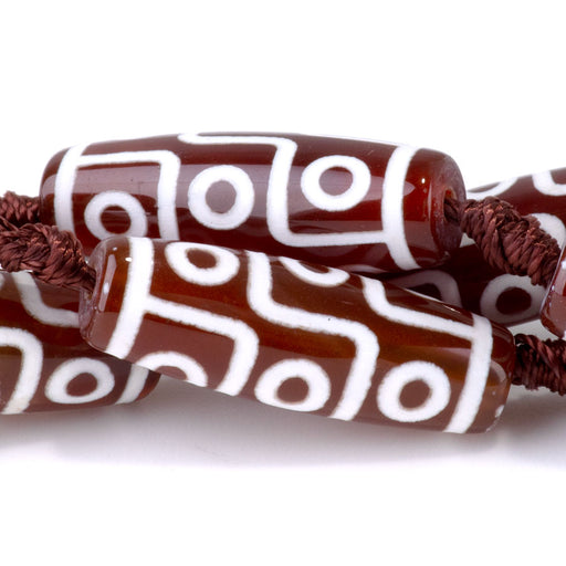 This is a Dakota Stones 10x30mm DZI Agate Nine Eye Red Gemstone strand with barrel beads in 15-16 inch strand.