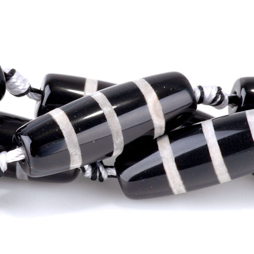 This is a Dakota Stones 10x30mm DZI Agate Line Black Gemstone strand with barrel beads in 15-16 inch strand.