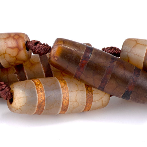 This is a Dakota Stones 10x30mm DZI Agate Line Brown Gemstone strand with barrel beads in 15-16 inch strand.