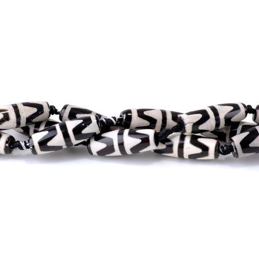 This is a Dakota Stones 10x30mm DZI Agate Tiger Teeth Black Gemstone strand with barrel beads in 15-16 inch strand.