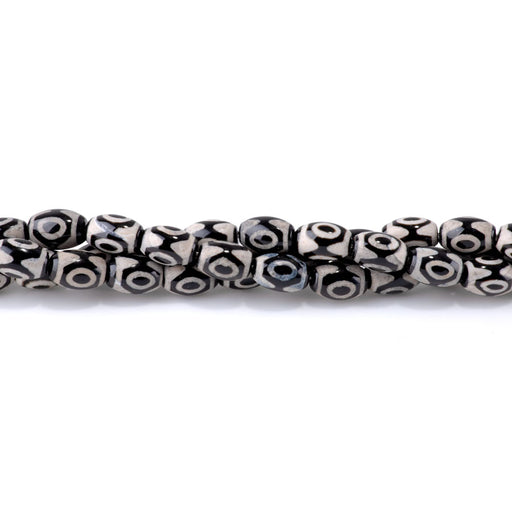 This is a Dakota Stones 8x12mm DZI Agate Black Eye Gemstone strand with barrel beads in 15-16 inch strand.