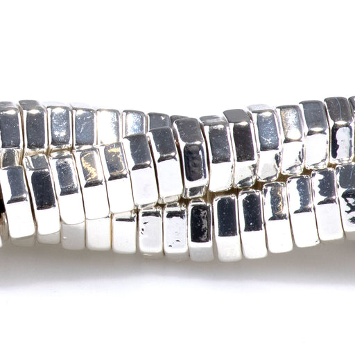 This is a Dakota Stones Hematite White Silver Plated Hexagon Gemstone strand of round beads in 15-16 inch strand.