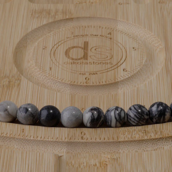 This is a Dakota Stones 10mm Black Picasso Jasper Large Hole Gemstone strand with round beads in 8 inch strand.