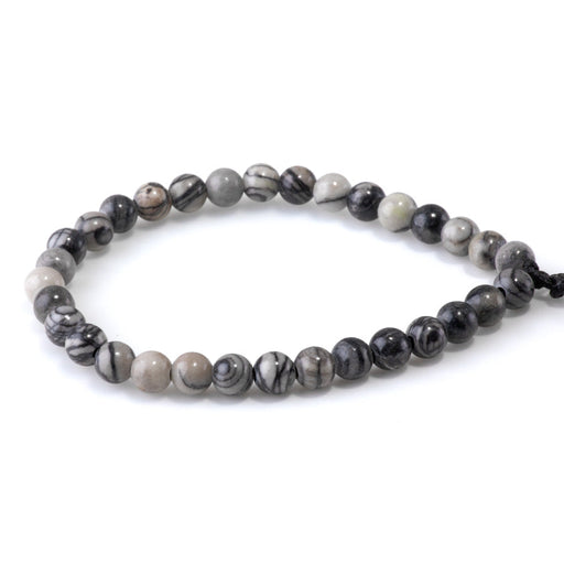 This is a Dakota Stones 6mm Black Picasso Jasper Large Hole Gemstone strand with round beads in 8 inch strand.