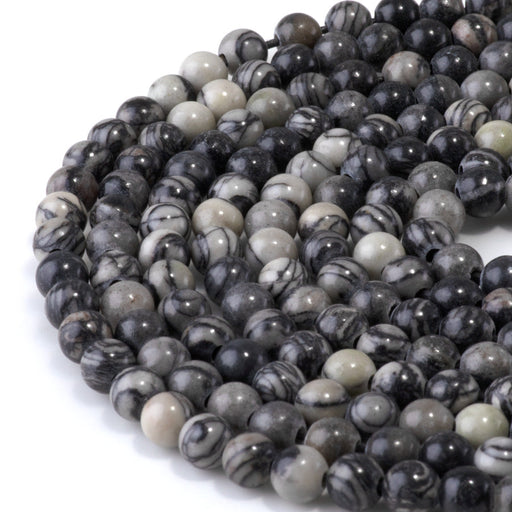 This is a Dakota Stones 6mm Black Picasso Jasper Large Hole Gemstone strand with round beads in 8 inch strand.