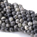 This is a Dakota Stones 6mm Black Picasso Jasper Large Hole Gemstone strand with round beads in 8 inch strand.