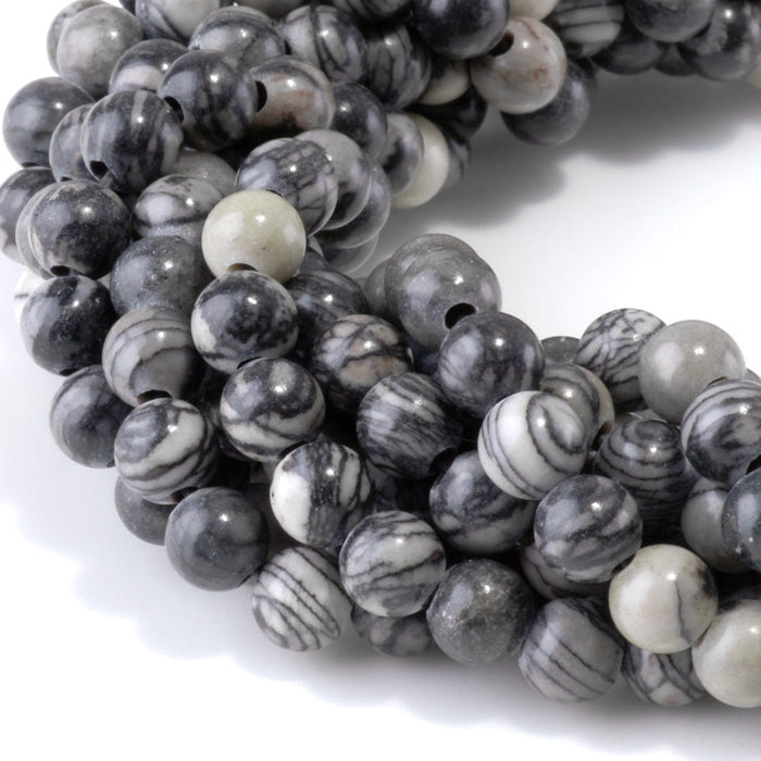 This is a Dakota Stones 6mm Black Picasso Jasper Large Hole Gemstone strand with round beads in 8 inch strand.