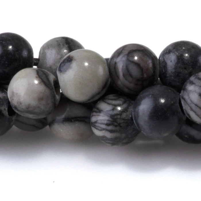 This is a Dakota Stones 6mm Black Picasso Jasper Large Hole Gemstone strand with round beads in 8 inch strand.