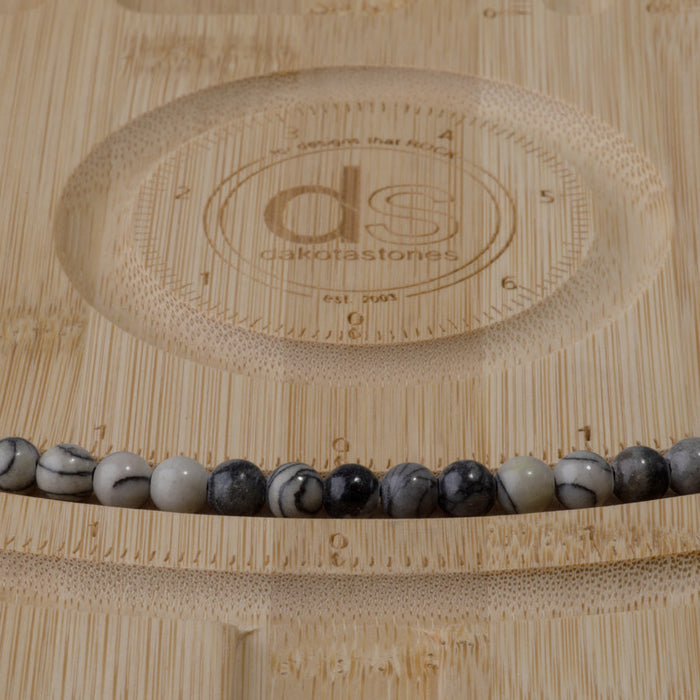This is a Dakota Stones 6mm Black Picasso Jasper Large Hole Gemstone strand with round beads in 8 inch strand.