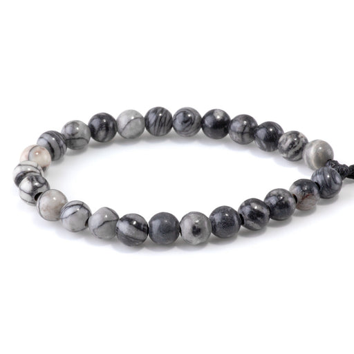 This is a Dakota Stones 8mm Black Picasso Jasper Large Hole Gemstone strand with round beads in 8 inch strand.