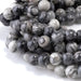 This is a Dakota Stones 8mm Black Picasso Jasper Large Hole Gemstone strand with round beads in 8 inch strand.