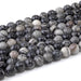 This is a Dakota Stones 8mm Black Picasso Jasper Large Hole Gemstone strand with round beads in 8 inch strand.