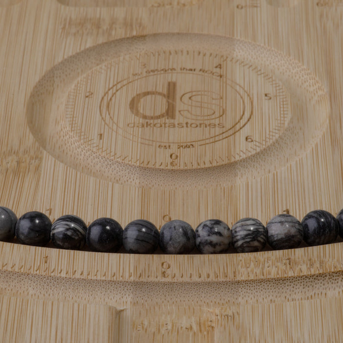 This is a Dakota Stones 8mm Black Picasso Jasper Large Hole Gemstone strand with round beads in 8 inch strand.