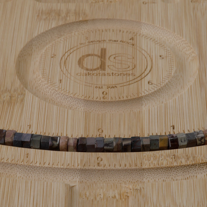 This is a Dakota Stones 6mm Red Creek Jasper Large Hole Gemstone strand with faceted hexagon beads in 8 inch strand.