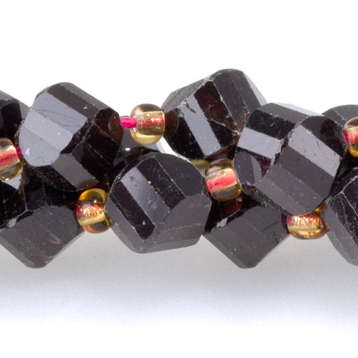 This is a Dakota Stones 7x8mm Red Garnet Swirl Gemstone strand with faceted oval beads in 15-16 inch strand.