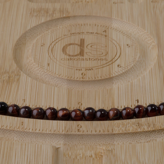 This is a Dakota Stones 6mm Red Tiger Eye Large Hole Gemstone strand with round beads in 8 inch strand.