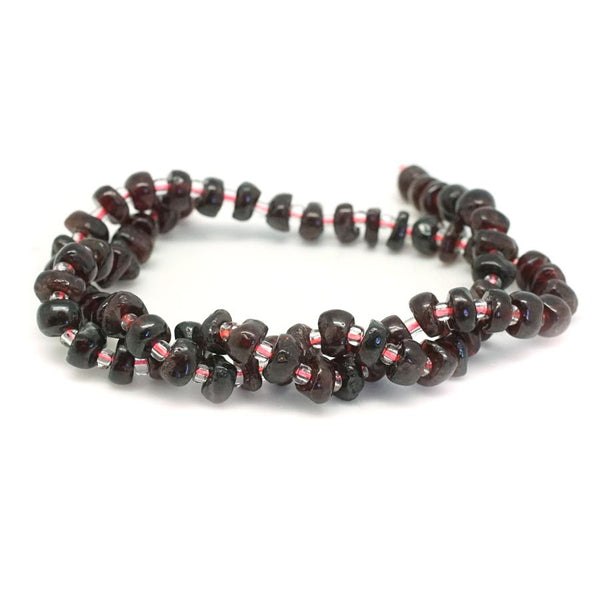 This is a Dakota Stones 5x8mm Red Garnet Chips Gemstone strand of round beads in 15-16 inch strand.